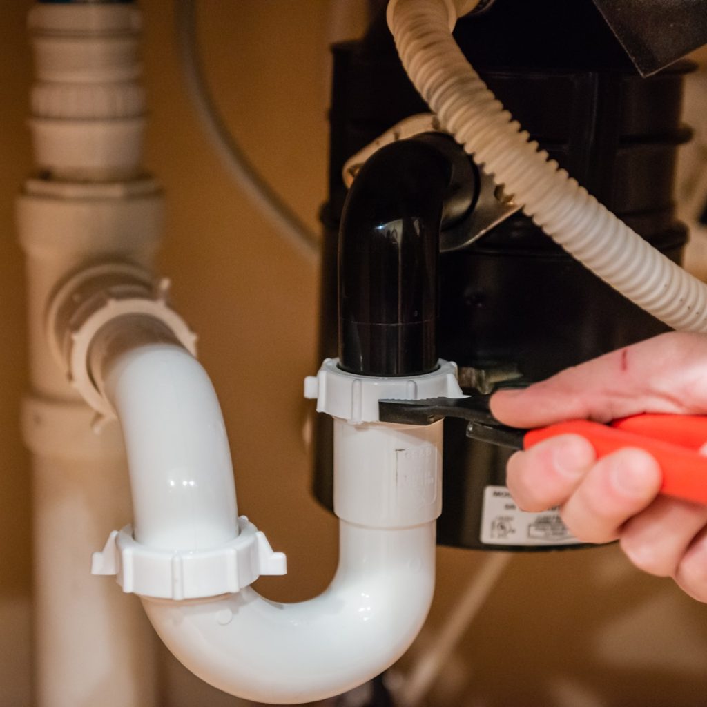 A plumbing contractor adjusts new pipes.
